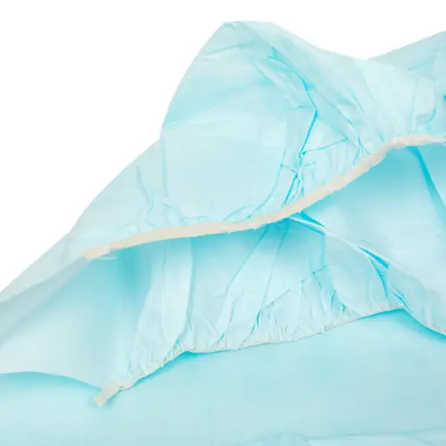 Close-up of light blue disposable protective gown material with elastic cuffs and gathered seams on a white background.