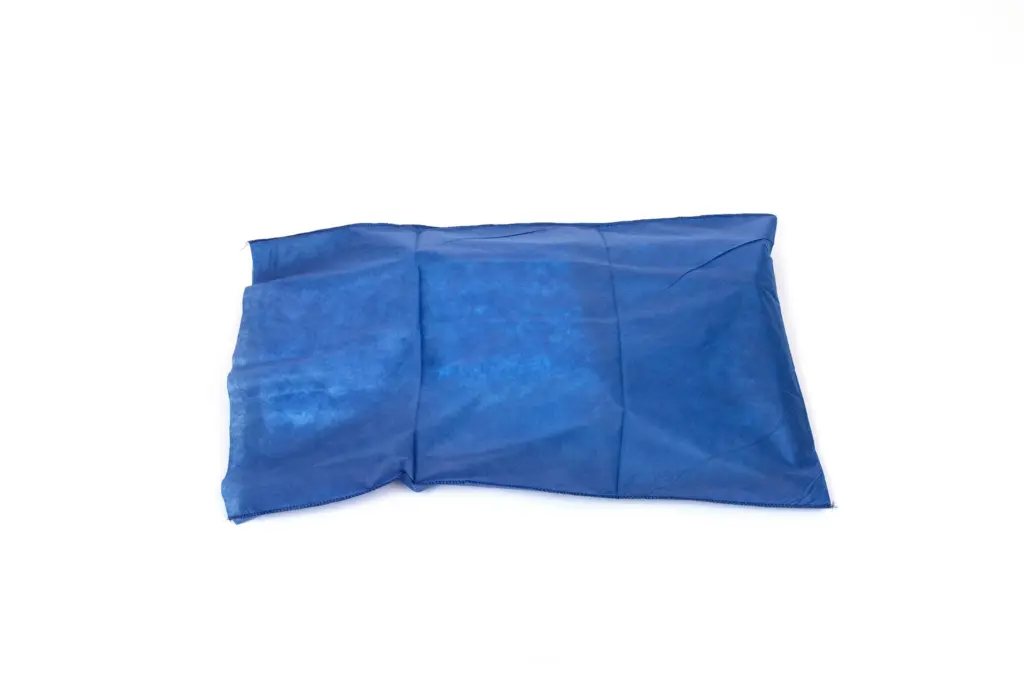Wrinkled blue rectangular fabric sandbag or weighted cushion lying flat against a plain white background.