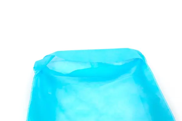 Open blue nonwoven fabric bag on white background Close-up of an open bright blue nonwoven fabric bag with folded edges and stitched side seams against white.