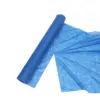 Blue nonwoven fabric roll partially unrolled across a white background, showing its thin textured material and wide sheet.