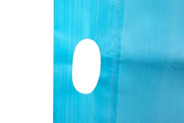 Close-up of blue textured fabric with white oval Blue textured material featuring a vertical stitched seam and a smooth white oval detail against a plain background