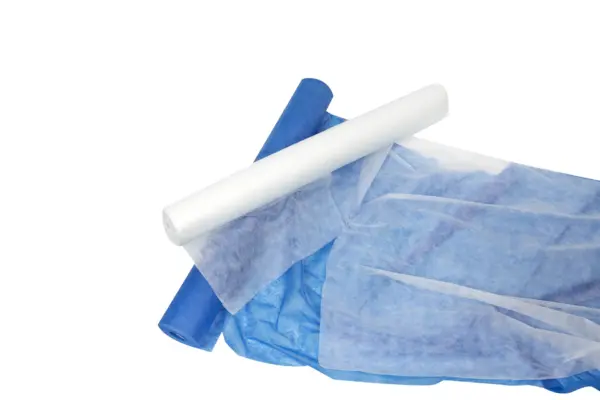 Blue and white rolled nonwoven fabric overlap on a white background, with translucent material spread across the lower frame.