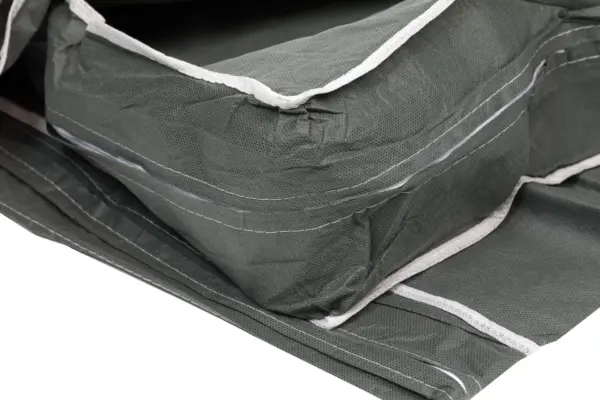 Stacked green fabric organizers with white trim Close-up of folded dark green fabric organizers featuring textured material, white edging, stitched seams, and layered panels.