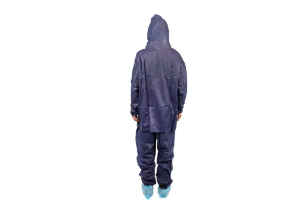 Back view of hooded protective coverall Person shown from behind wearing a dark blue hooded protective coverall with matching trousers and light blue shoe covers.