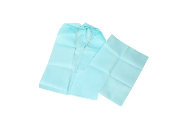 Light blue disposable plastic rain poncho with a drawstring hood, laid flat beside a folded matching section.