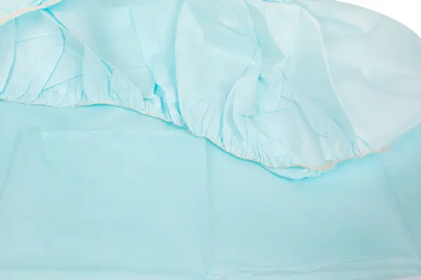 Close-up of pale blue lightweight fabric, showing gathered elastic edging, soft folds, and a smooth textile surface.