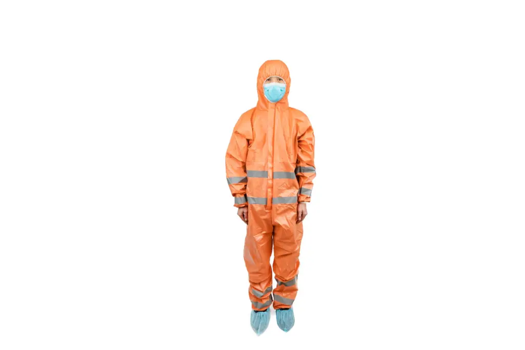Person in an orange hooded protective coverall with reflective bands, blue face mask, and blue shoe covers