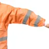 Orange reflective jacket sleeve on white background Cropped person wearing an orange high-visibility jacket with gray reflective bands and an extended arm