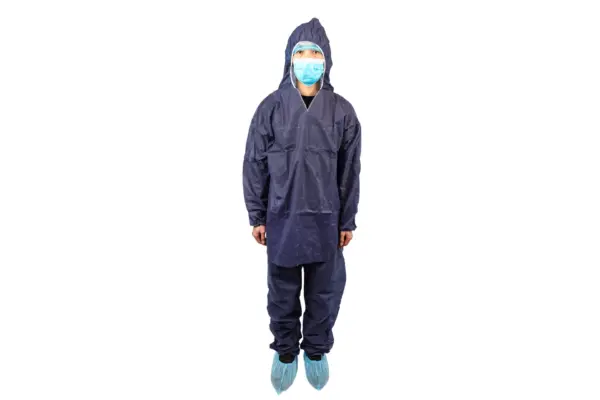 Front view of person in navy protective coveralls Person standing in navy hooded protective coveralls, blue face mask, hair cover, and disposable shoe covers on white background.