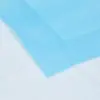 Close-up of a translucent blue sheet layered diagonally across a pale white surface with soft wrinkles and texture.