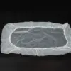 Transparent plastic cover with elastic edge Translucent rectangular plastic cover with gathered elastic edging laid flat against a black background.