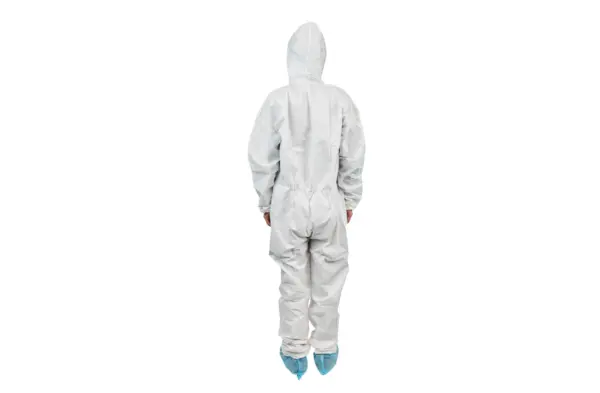 White hooded protective coverall viewed from behind Person wearing a white hooded protective coverall with elastic cuffs and blue shoe covers, shown from behind