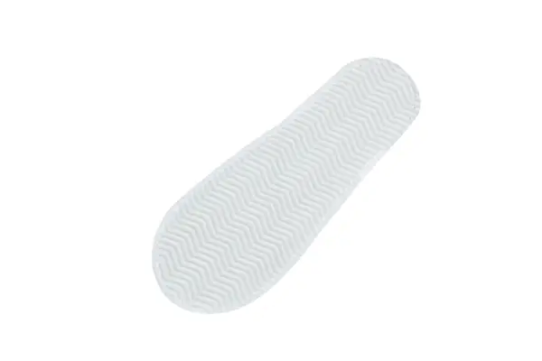 White shoe sole with zigzag tread pattern Close-up underside of a white shoe sole, showing a raised zigzag tread pattern against a plain white background.