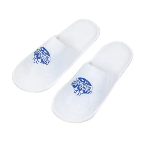 Pair of white open-back fabric spa slippers displayed on a plain white background, each featuring a blue printed logo.