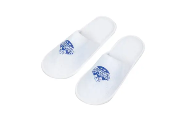 Pair of white open-back fabric spa slippers displayed on a plain white background, each featuring a blue printed logo.