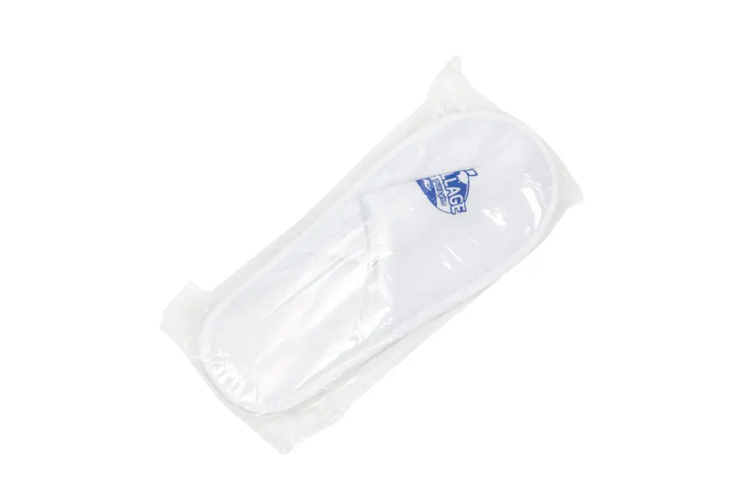 White folded textile product sealed in clear plastic packaging, featuring a small blue printed logo on the surface