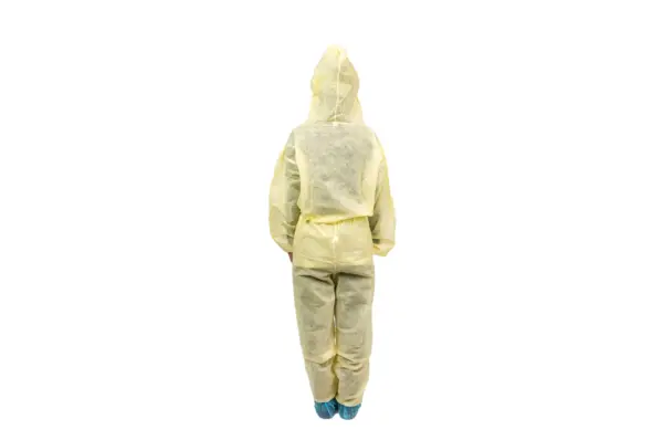 Back view of yellow protective coverall Person standing with their back to the camera in a yellow hooded protective coverall and blue shoe covers on white.