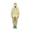 Person wearing protective coveralls and mask Person in yellow protective coveralls, hair cap, blue face mask, and shoe covers stands against a white background.